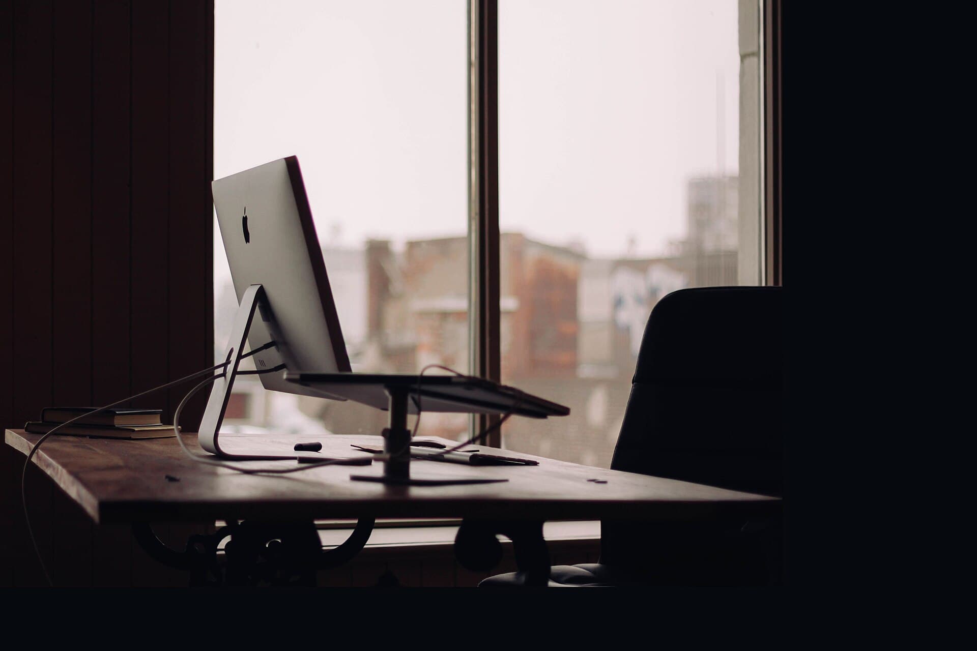 Minimal desk with a computer in a dark, quiet office