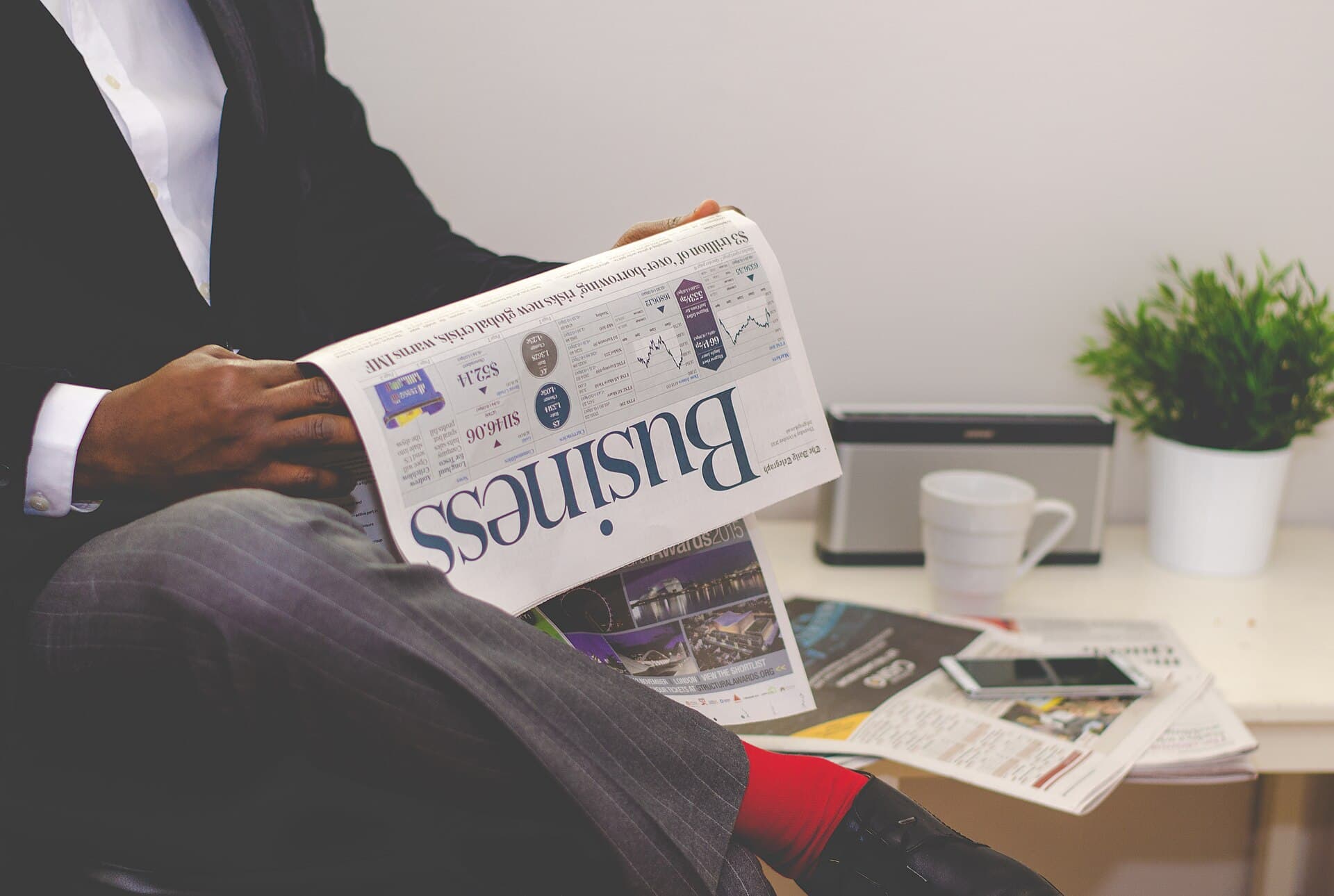 Person reading the business section of a newspaper